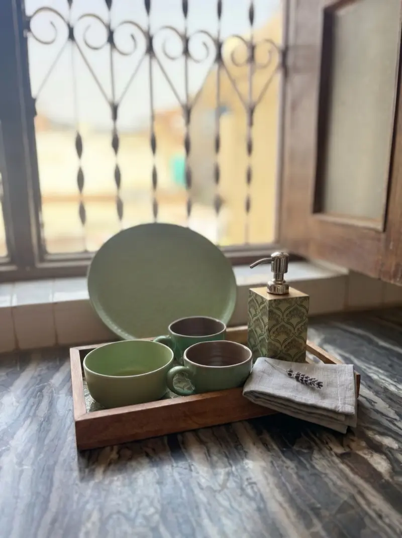 Green ceramic breakfast set on the marble sill